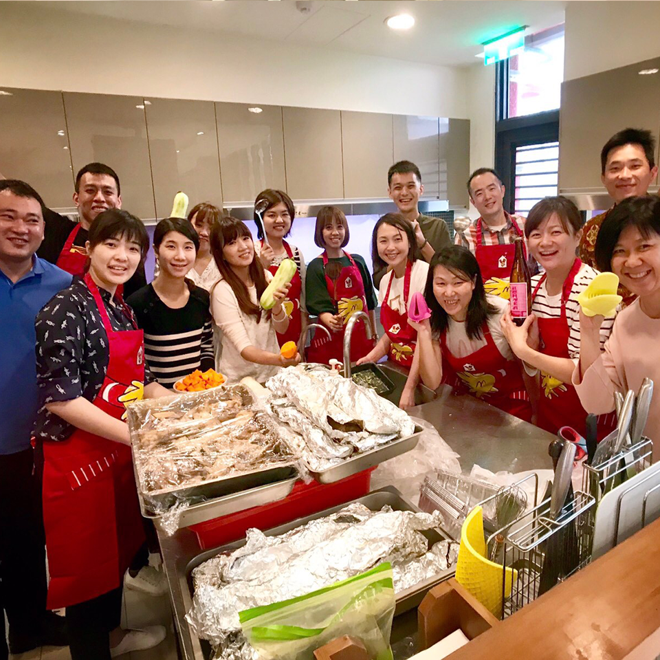 Colleagues from an RMHC corporate partner who donated their time posing around food prepared at their local Ronald McDonald House program
