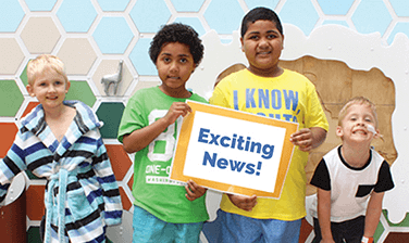 Article Preview: four children, two in center holding "Exciting News!" sign