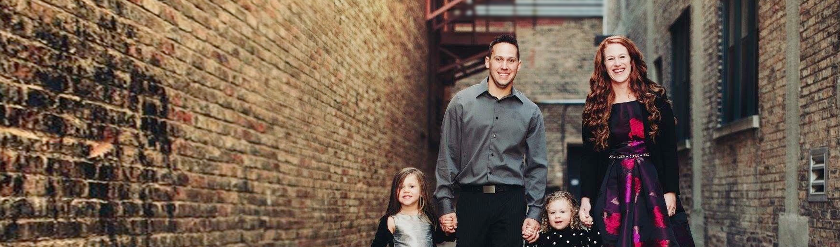 The Ledvinas, an RMHC family, posed holding hands in a picturesque brick-lined alley