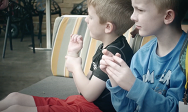 Children sitting outside on patio furniture