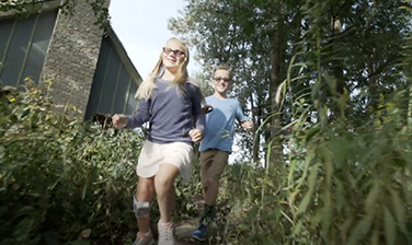 Children running through foliage