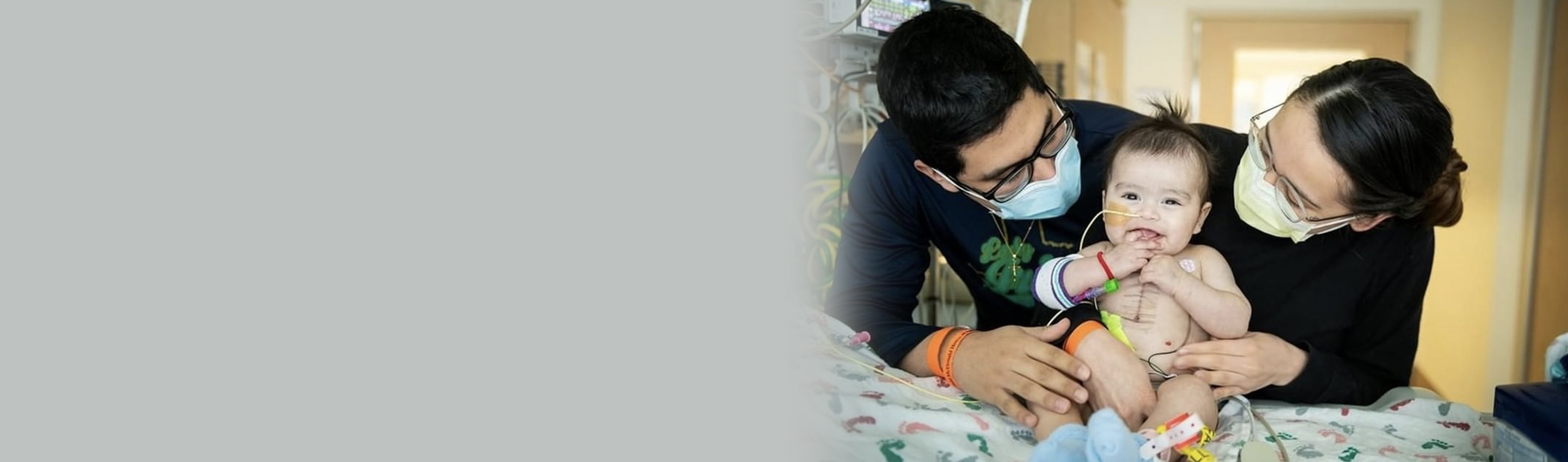 RMHC parents surround their infant in an embrace on a hospital bed